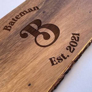 close up of personalized cutting board, says Bateman, Est. 2021 with large decorative B in middle