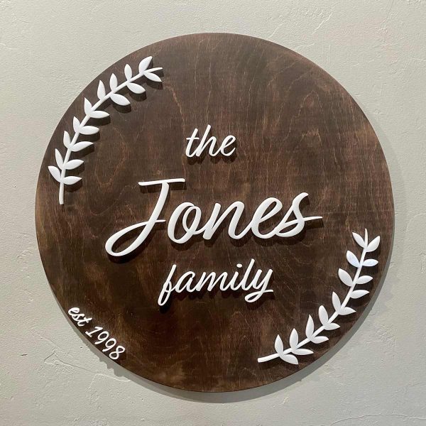round dark wood sign, white letters say Jones Family
